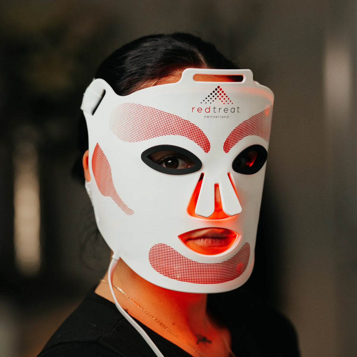 Frau trägt die redtreat SolisMask, LED-Gesichtsmaske mit rot leuchtenden Lichtfeldern